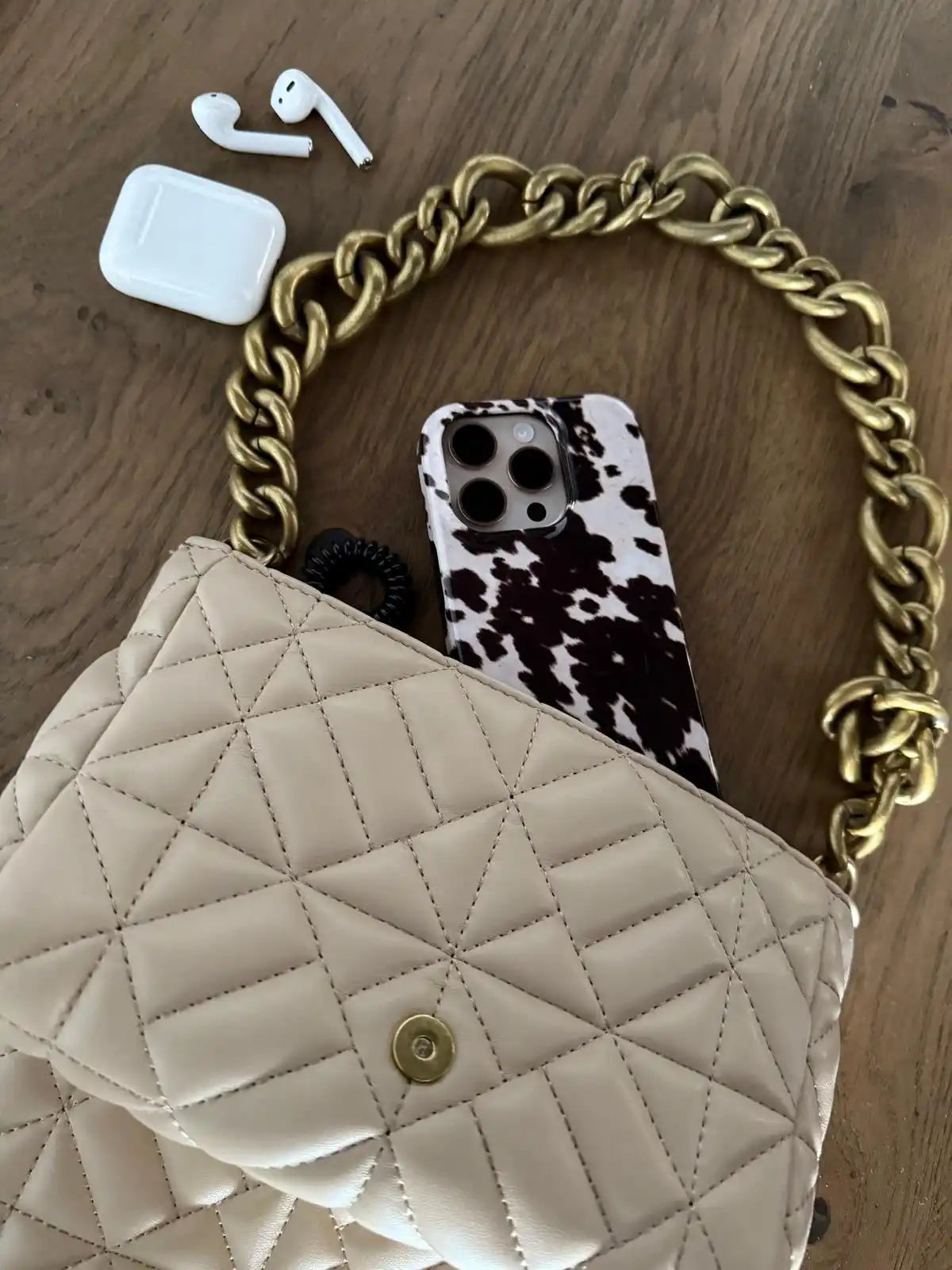 Beige quilted purse with gold chain.